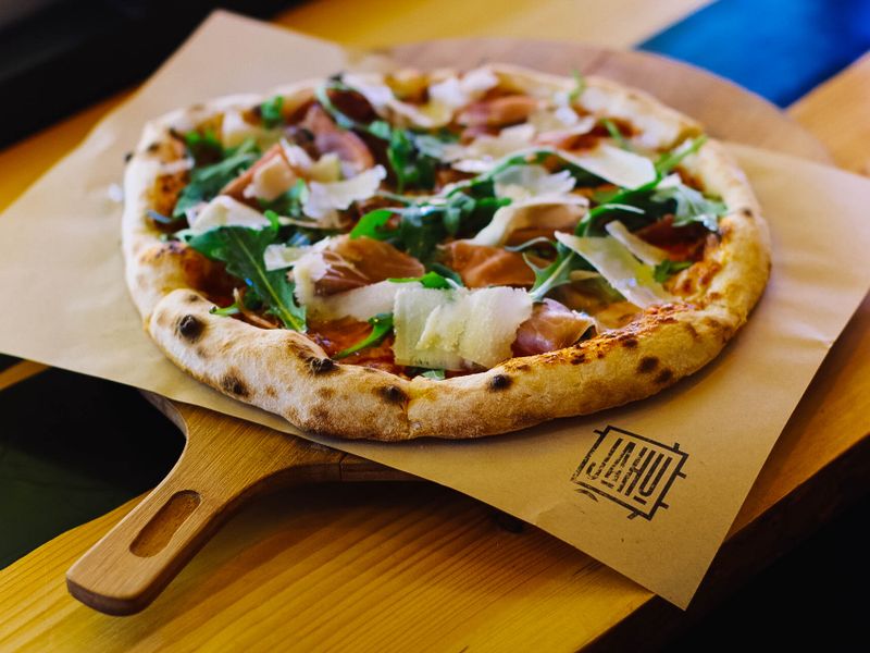 Flat-bread topped with greens and cheese