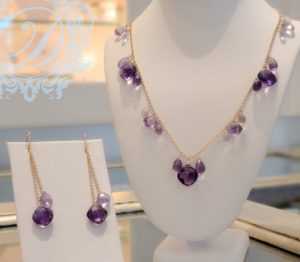 A purple amethyst necklace and matching earrings on display