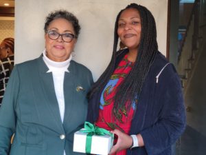 Two women exchange a gift at a Links, Incorporated event