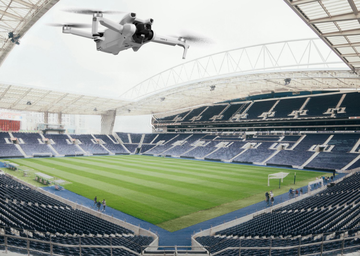 A camera drone flying over an empty stadium fitted with tracking rigs