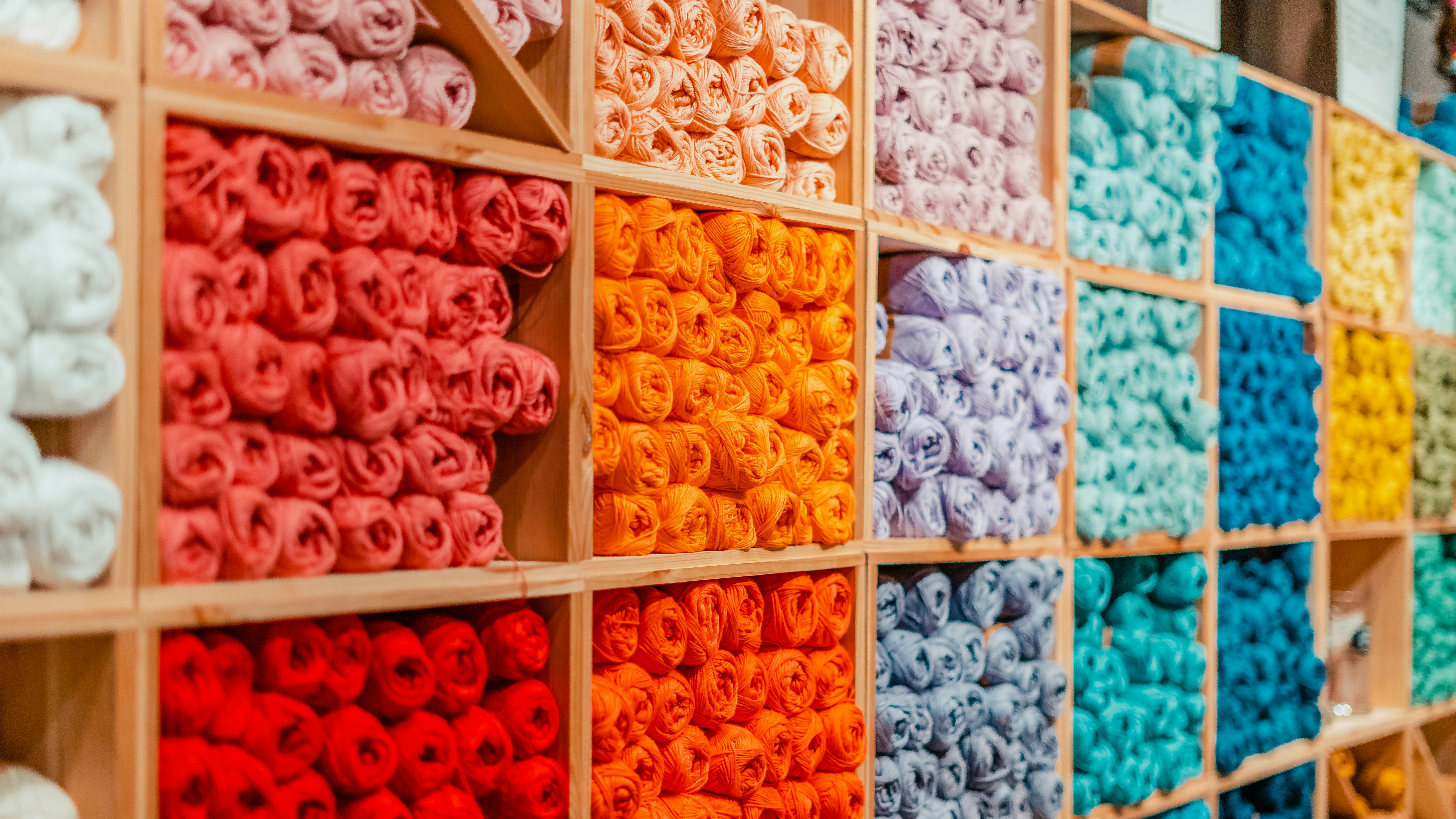 Colourful rolls of craft fabric arranged on shelves