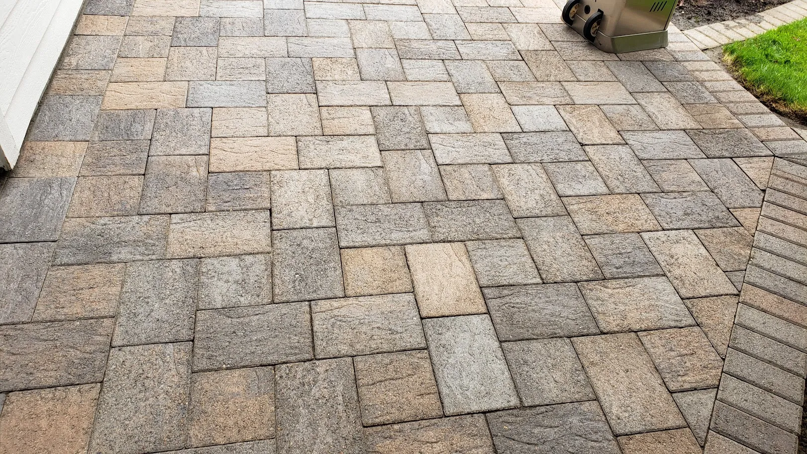 The same paver patio after restoration, with the joints cleared and the original tan and grey stone color visible again