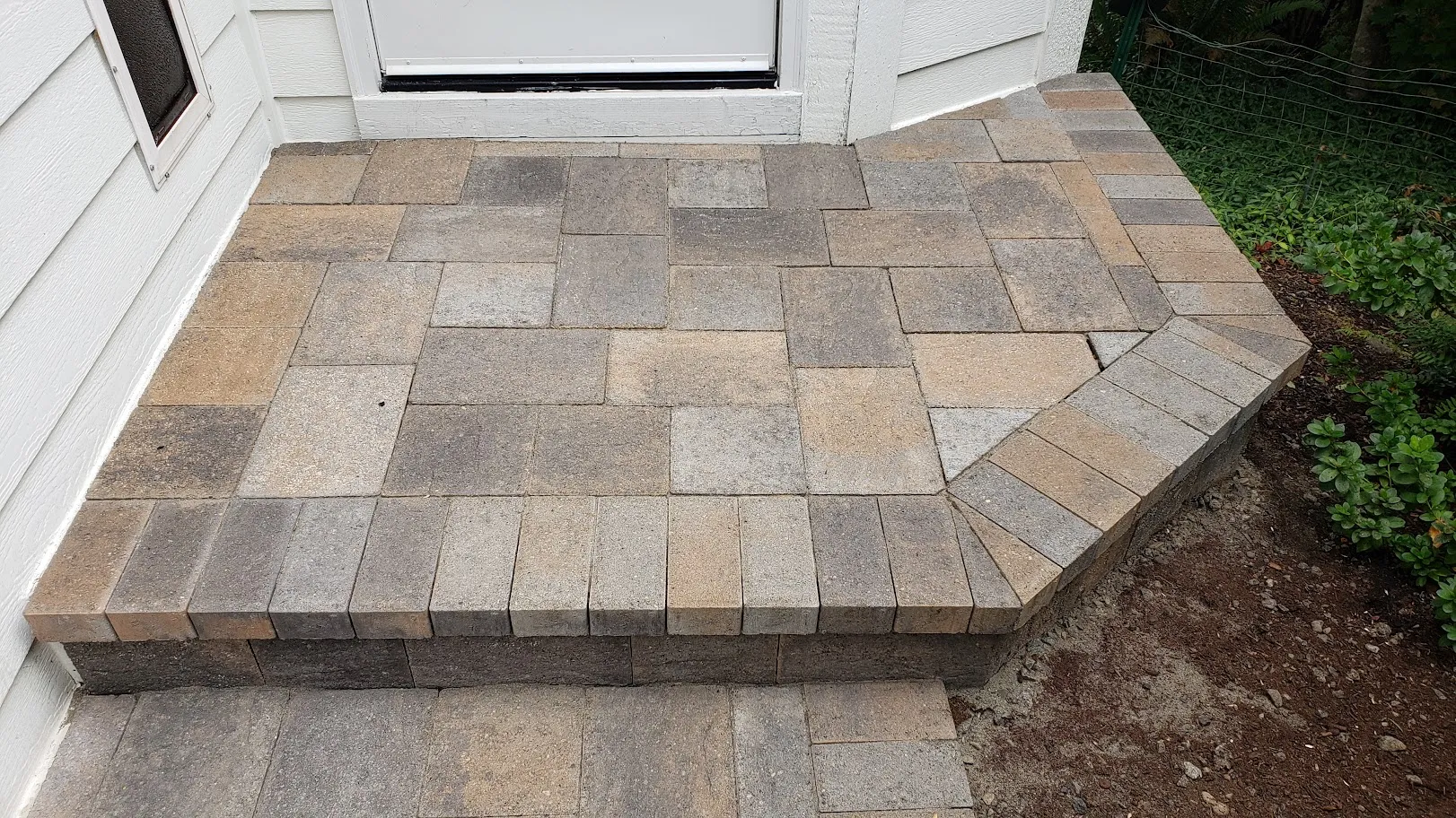 The same paver entry step and landing after restoration, cleaned back to clear tan and grey stone with defined joints