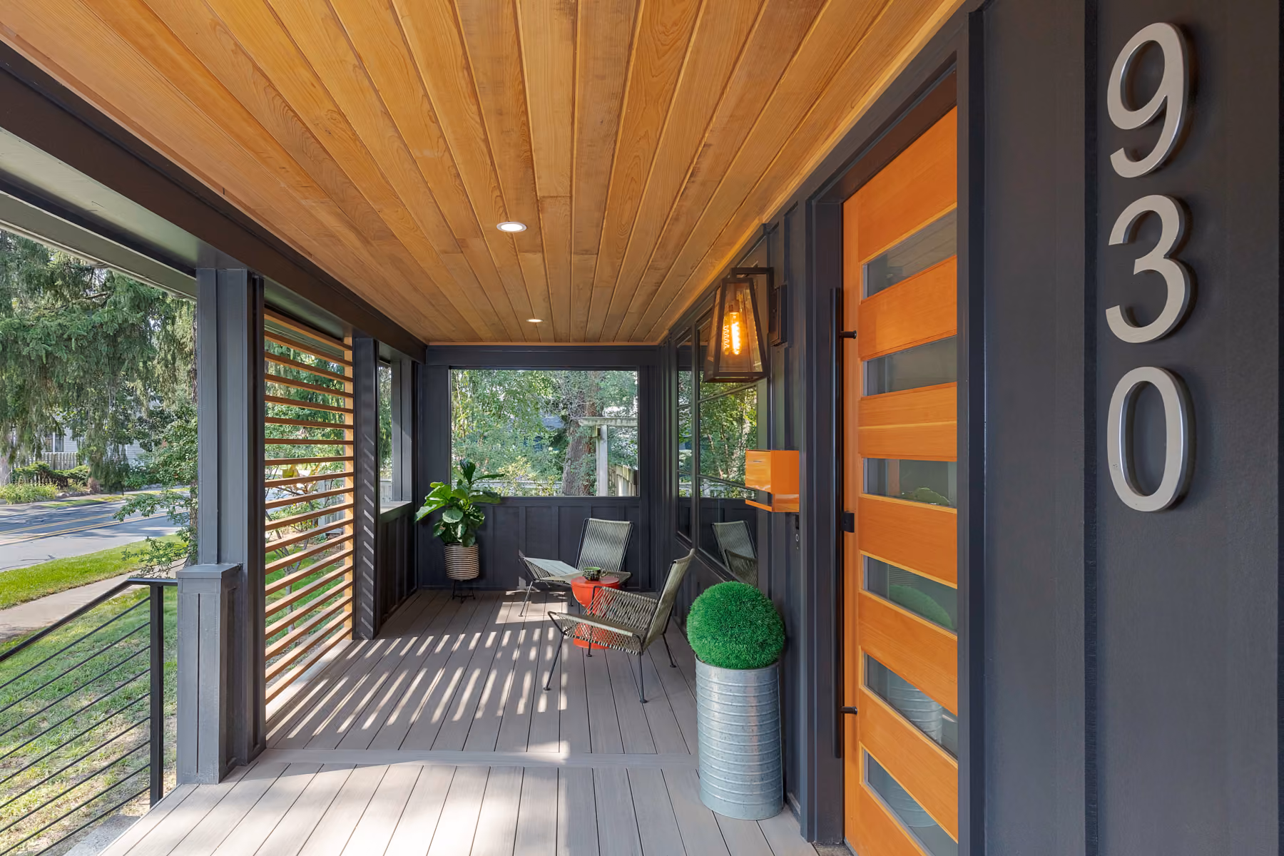 Front porch with a wood-plank ceiling, wood slat screen wall, and outdoor seating area