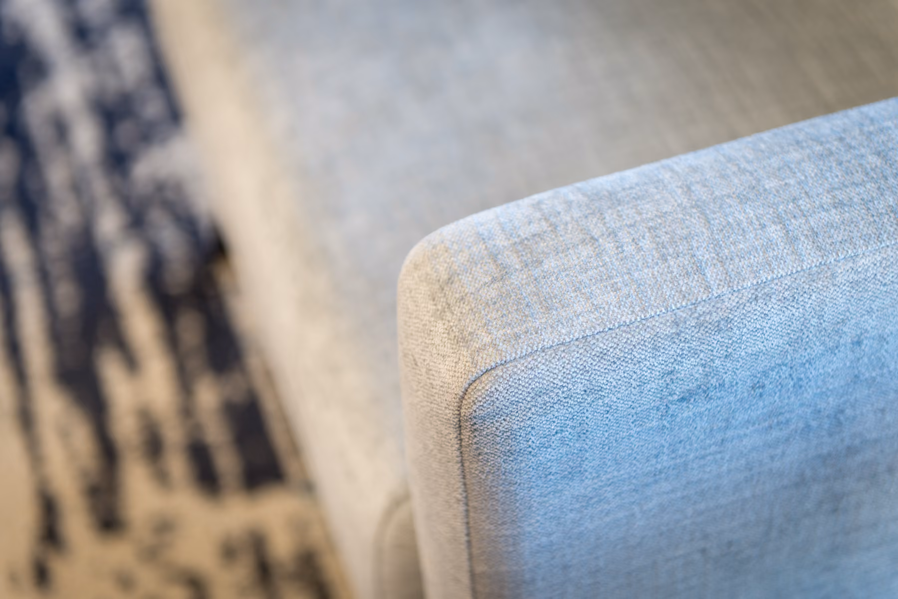 Close-up of woven gray upholstery on a lounge chair arm