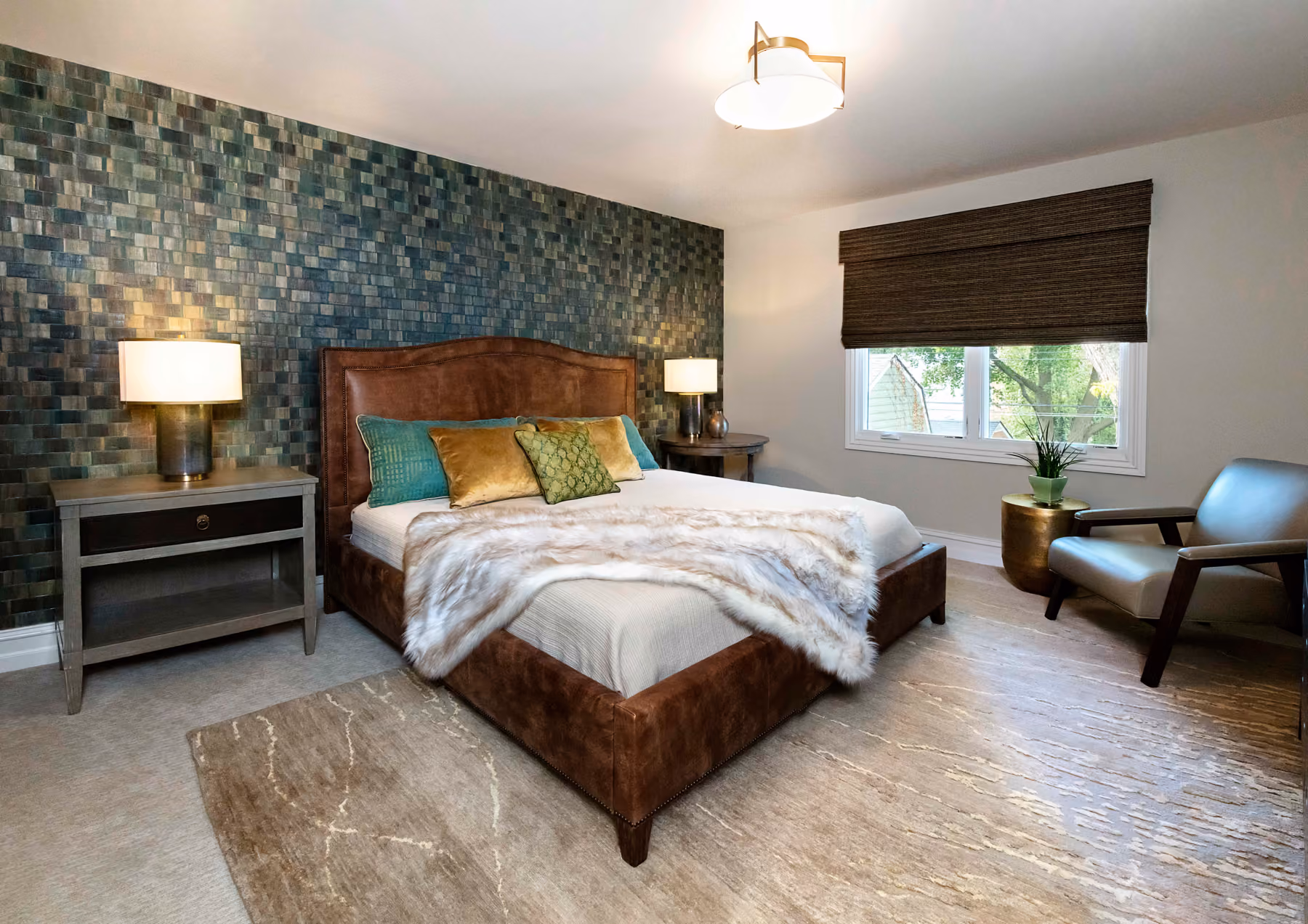 Bedroom with a teal mosaic-tile accent wall, a brown leather upholstered bed, and a faux-fur throw