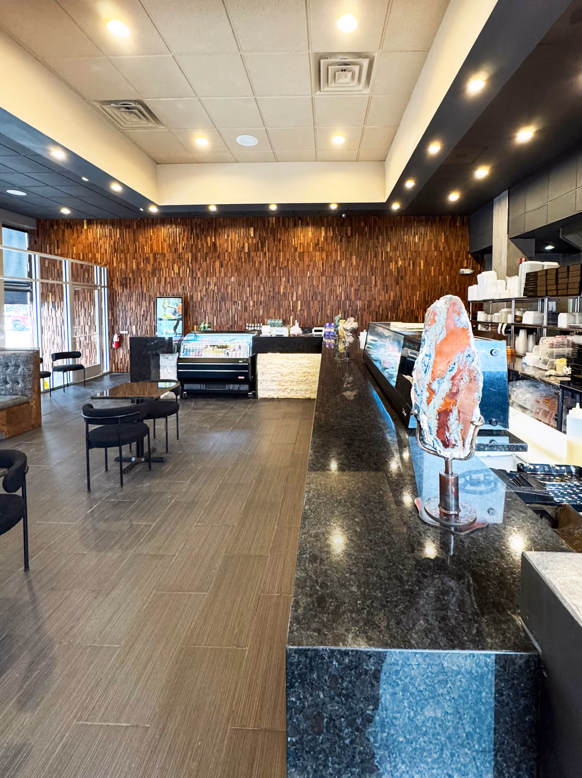Long granite counter with a natural stone sculpture and the dining area beyond