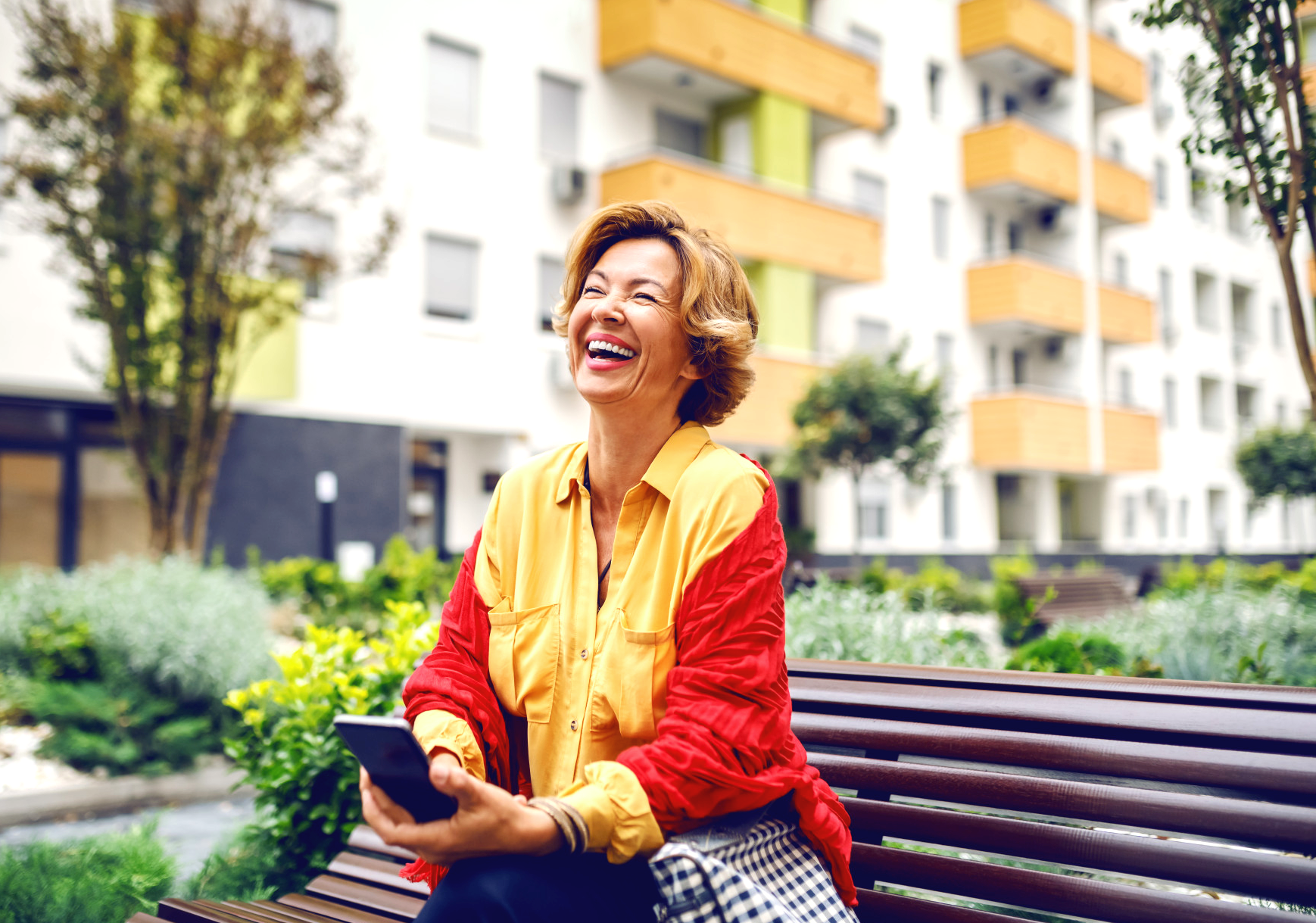 Smiling older woman outside a modern apartment community
