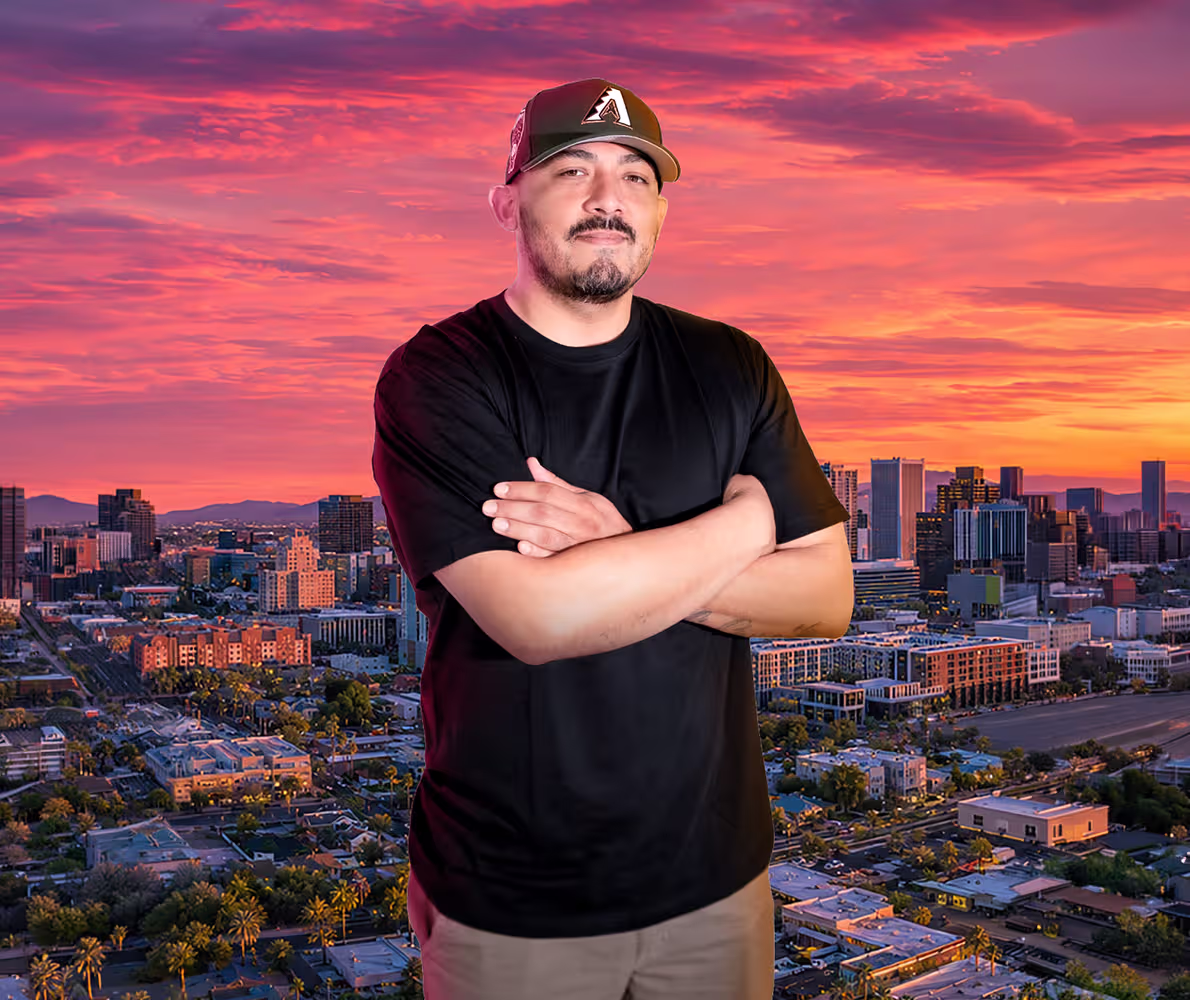 Dre, founder of Xolara Creative Agency, standing against a Phoenix sunset skyline