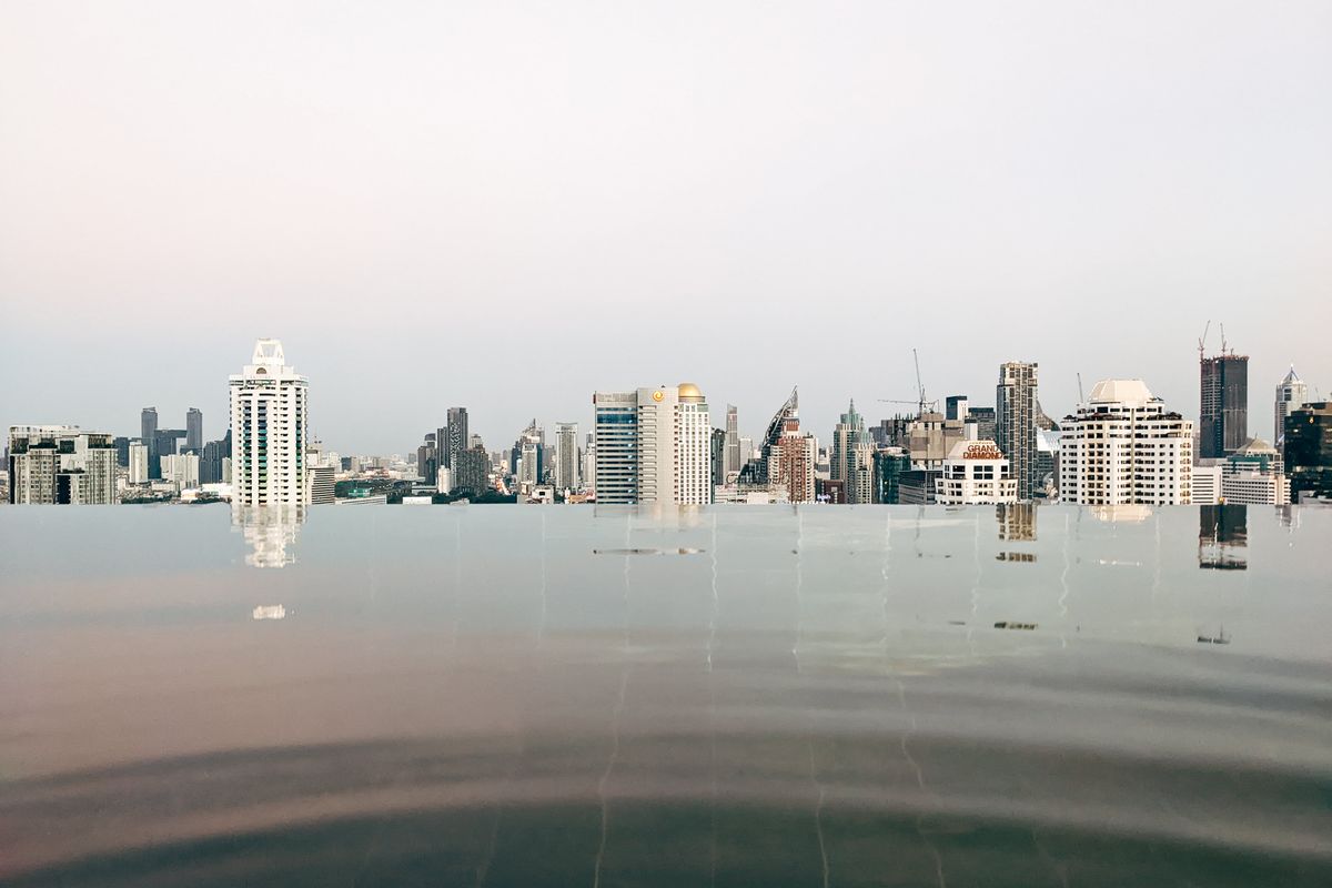 An infinity pool reflecting the Bangkok skyline at dusk