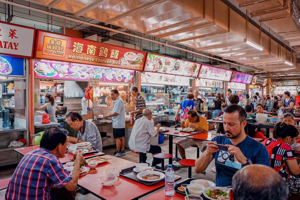 Diners sharing tables at a bustling Singapore hawker centre