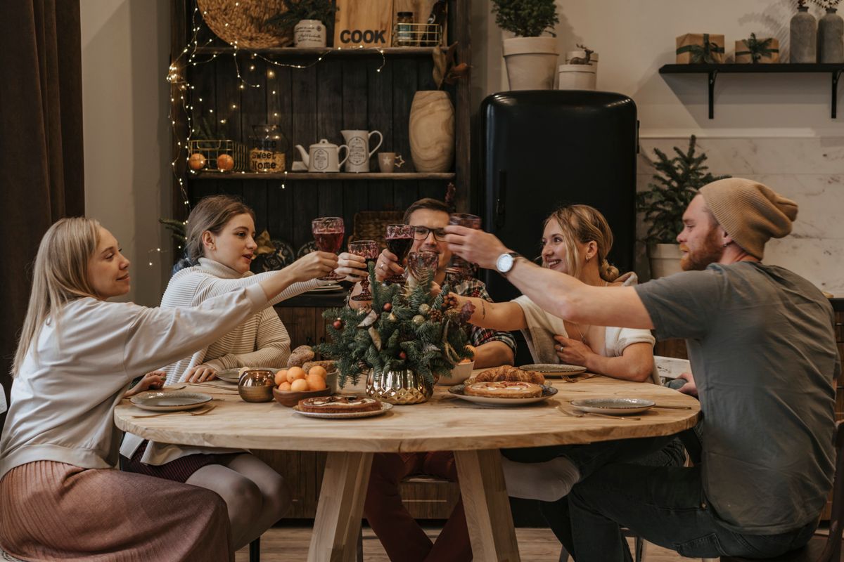 Friends raising a toast around a warmly lit dinner table