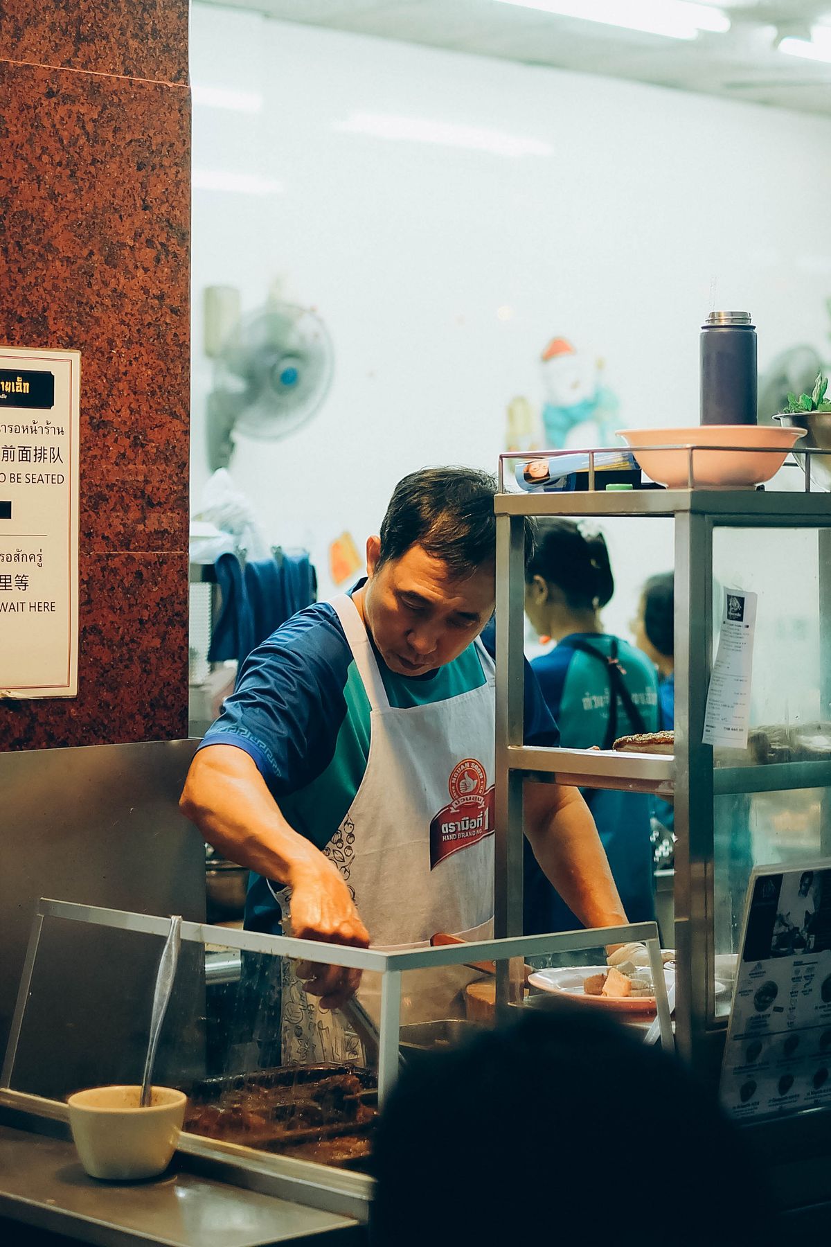 A street vendor cooking at a Bangkok night market
