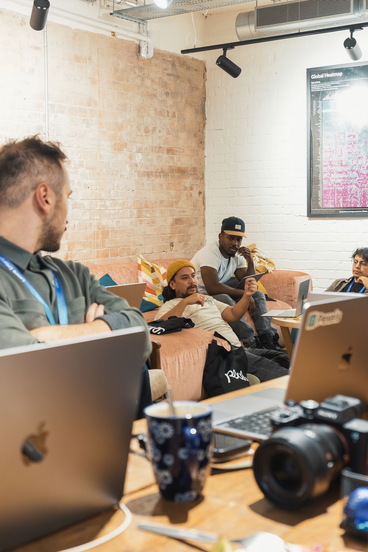 A team in easy conversation over laptops and coffee