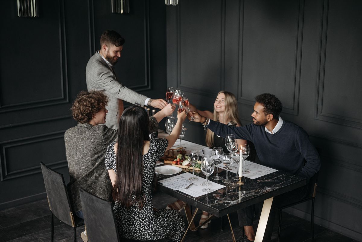 A well-dressed group raising glasses at a dinner table