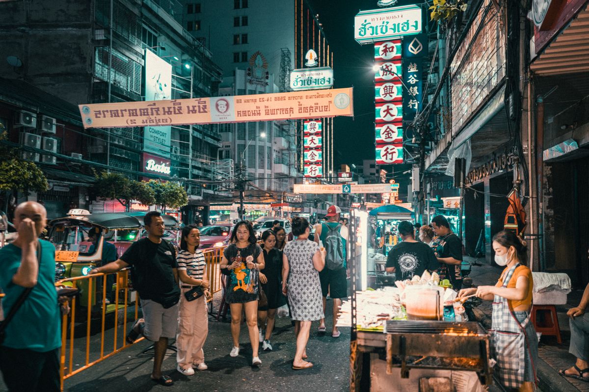 A crowded Bangkok street market glowing at night