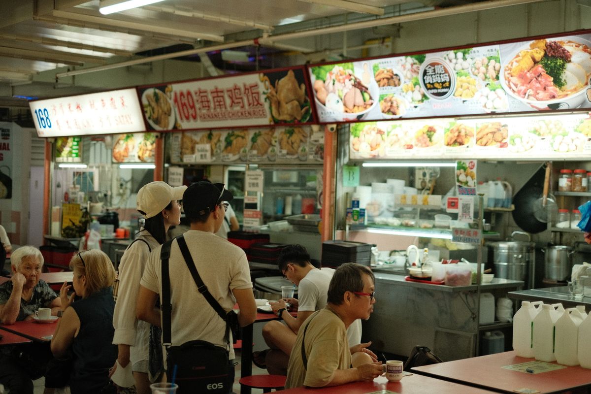 Diners enjoying local dishes at a Singapore hawker centre