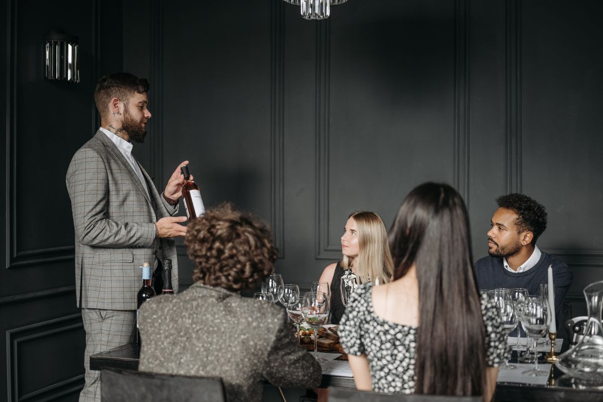A sommelier presenting wine to guests at a tasting