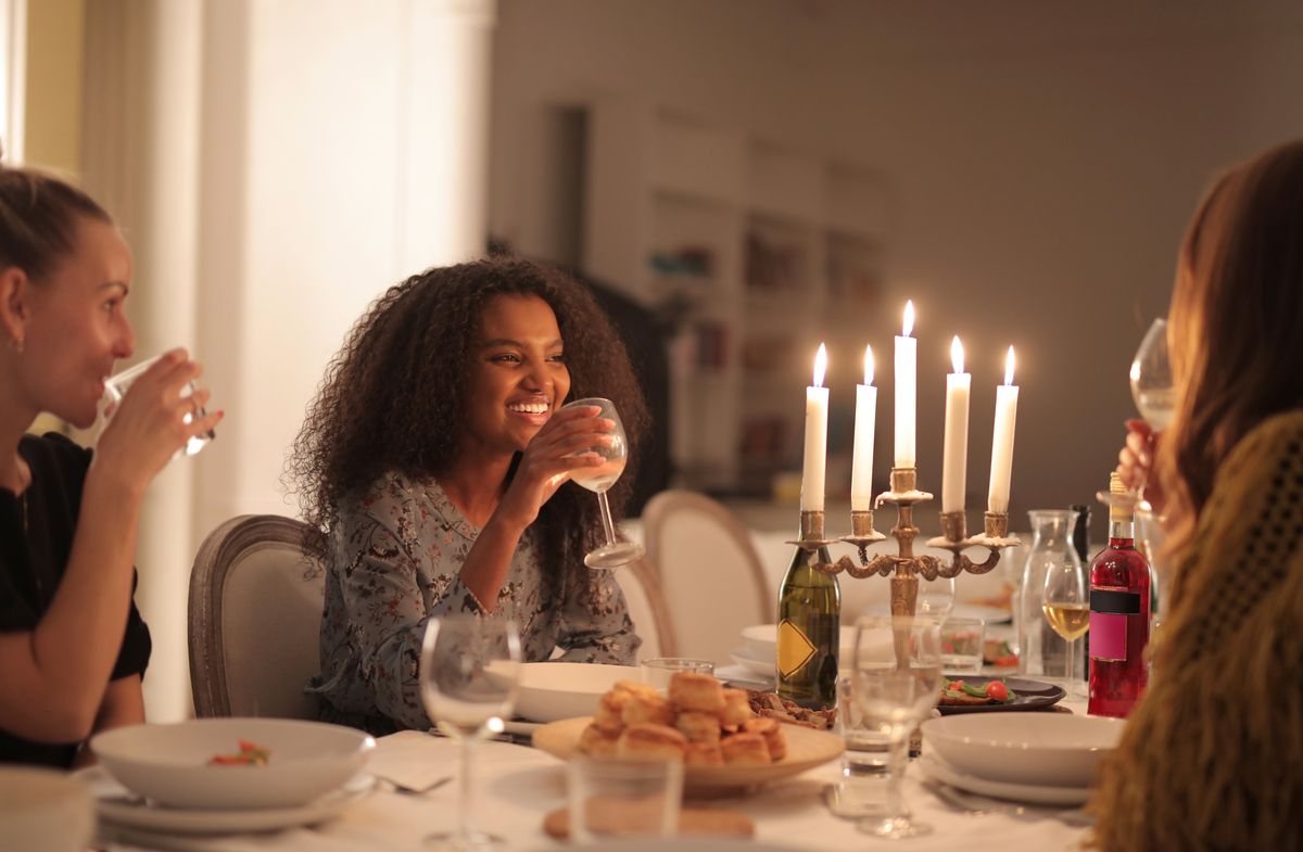 Friends enjoying wine and conversation by candlelight