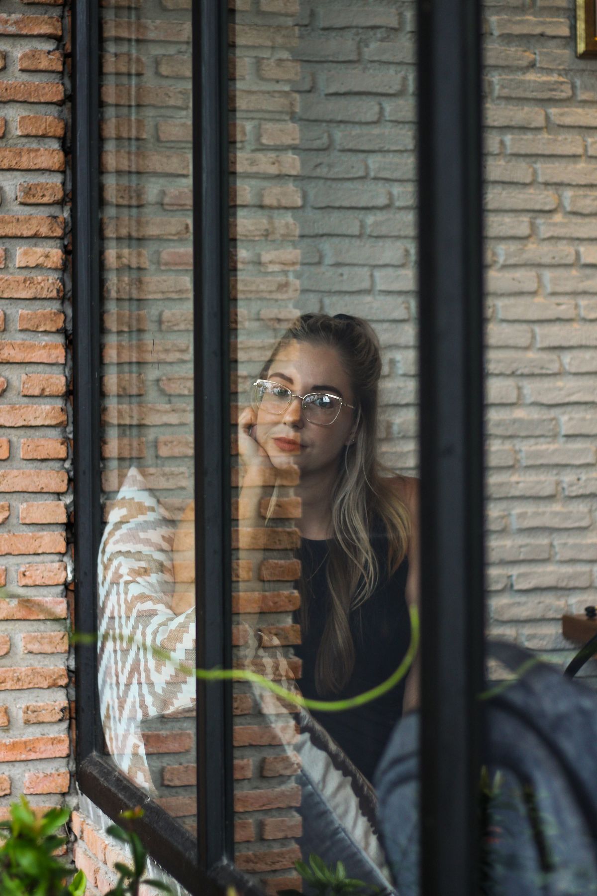 A woman gazing out of a café window in Thailand