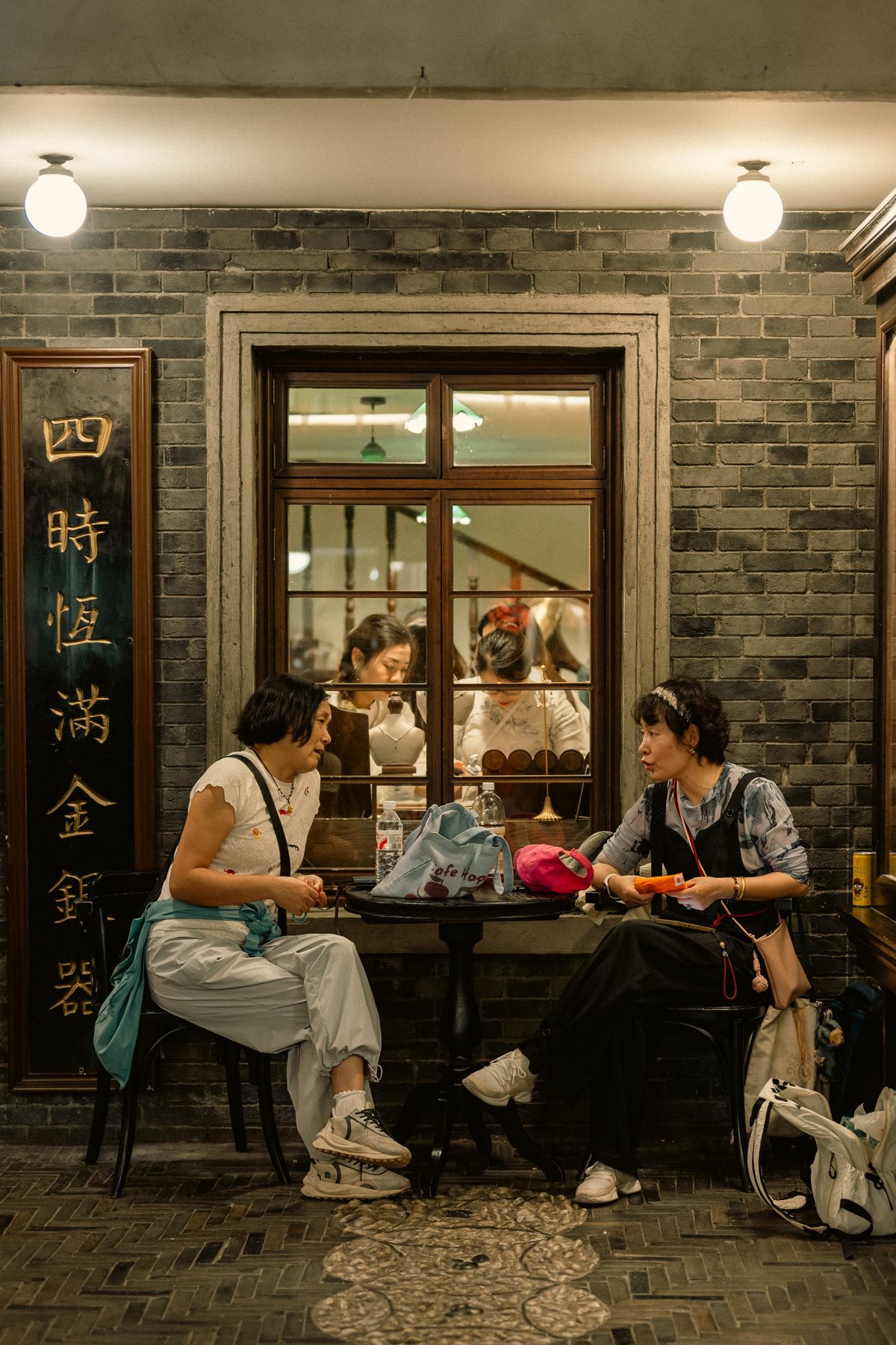 Two women deep in conversation in a café at night