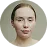 Portrait of a woman with pale skin, pulled-back hair, and neutral expression on a pale background.