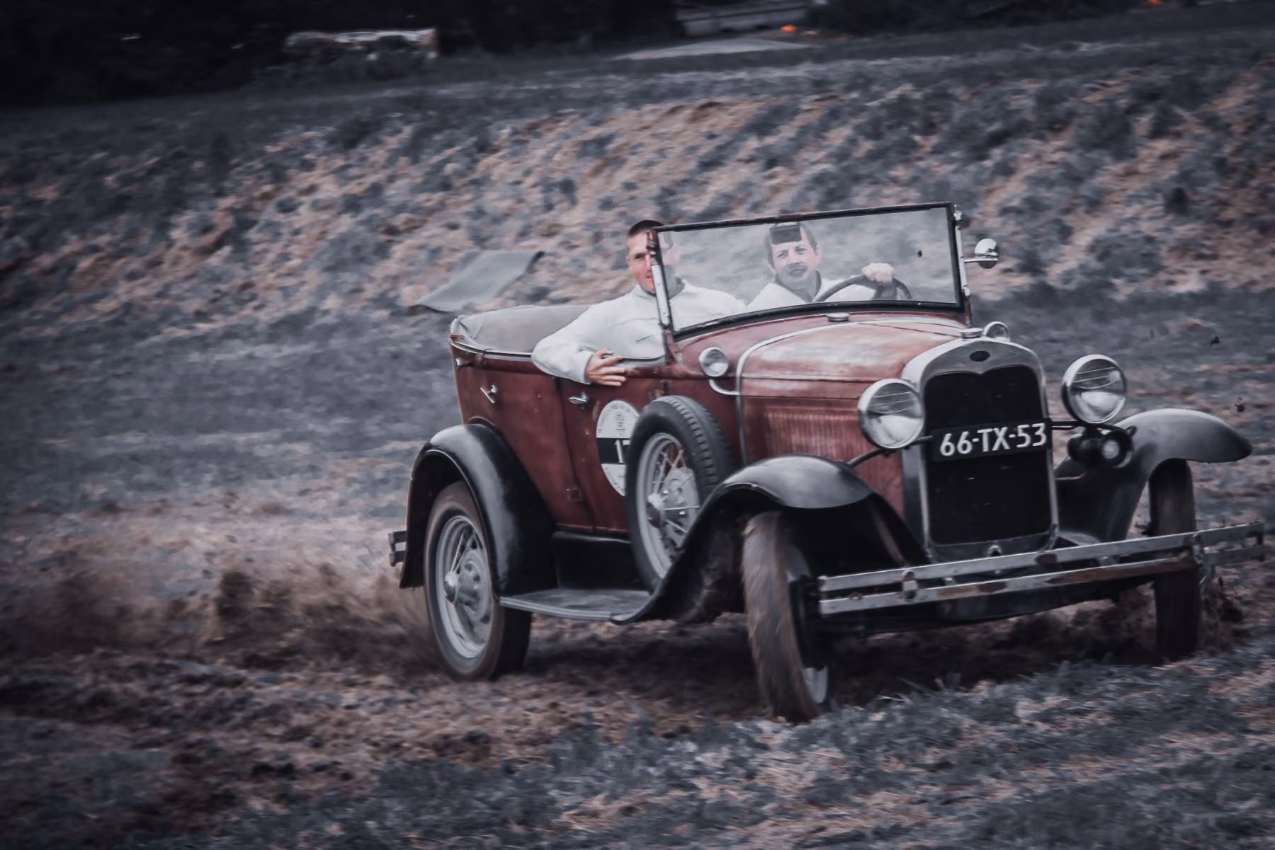 Vintage roadster door de modder
