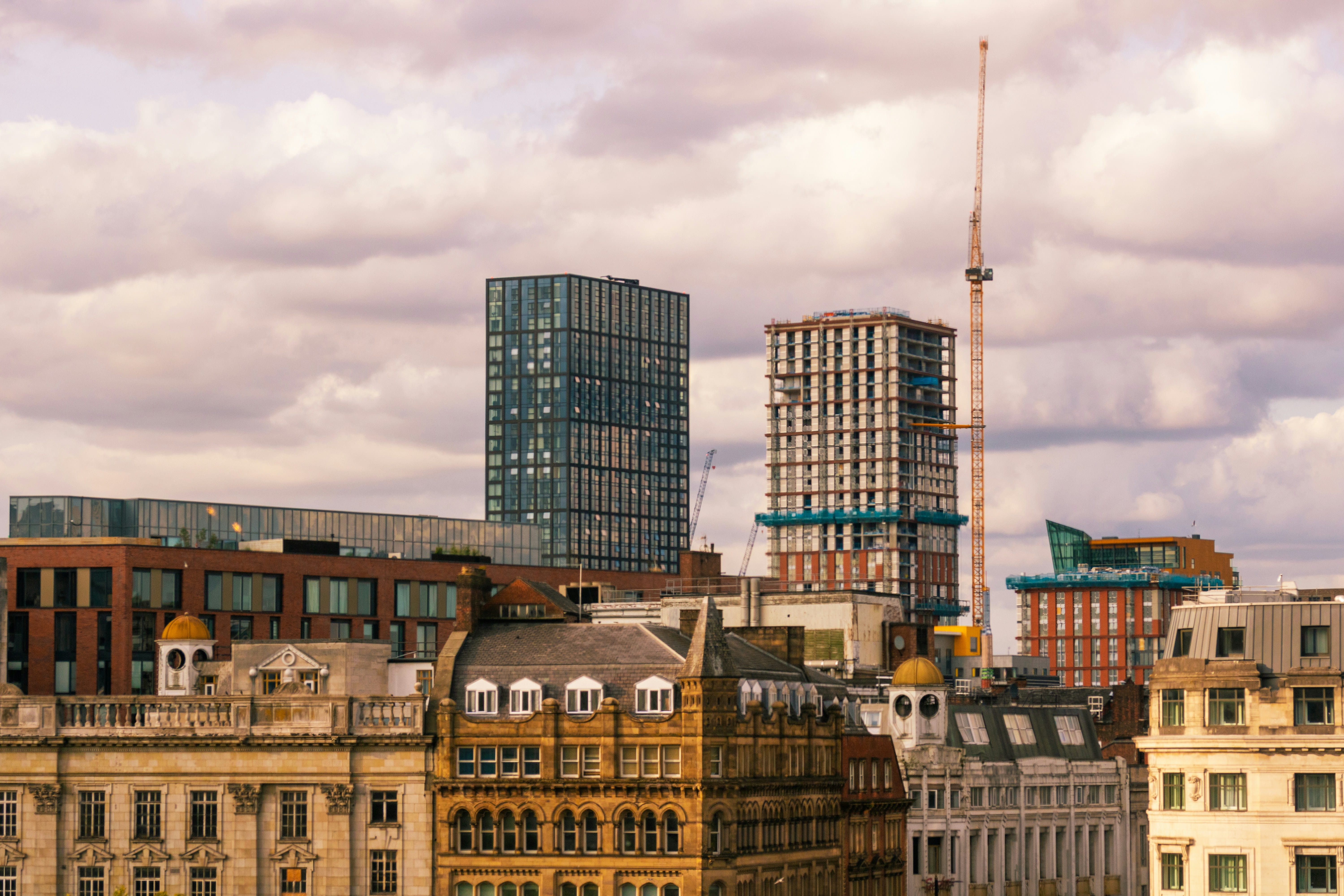 City skyline with old and modern buildings under a cloudy sky.