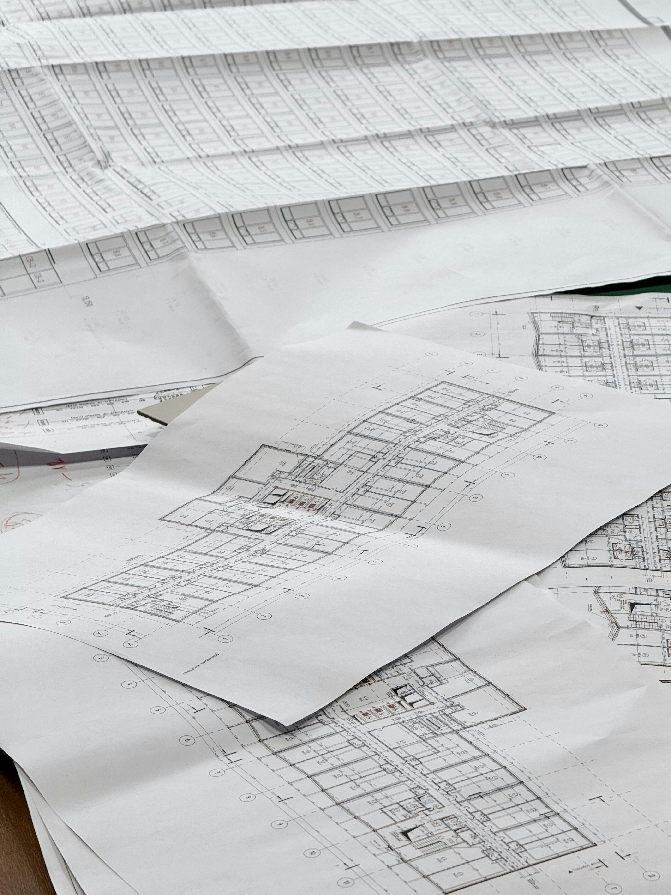 Several detailed architectural floor plans spread out on a table.