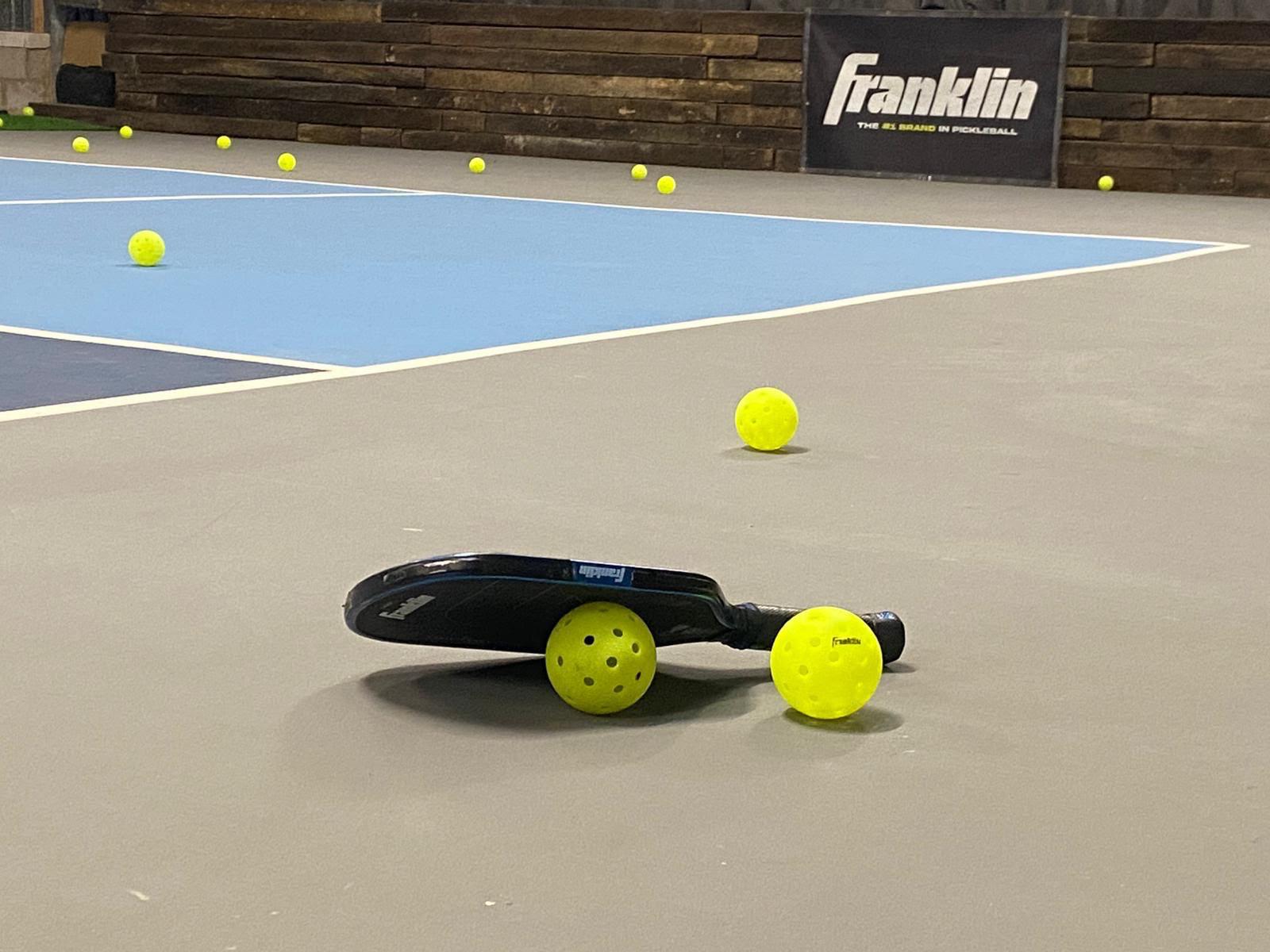 Pickleball paddle and balls on the championship court