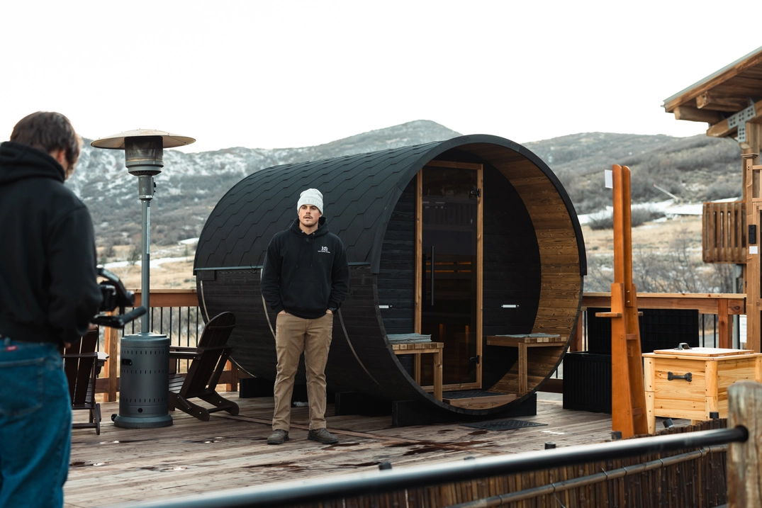 Guest standing beside a barrel sauna during a Soldier Hollow shoot