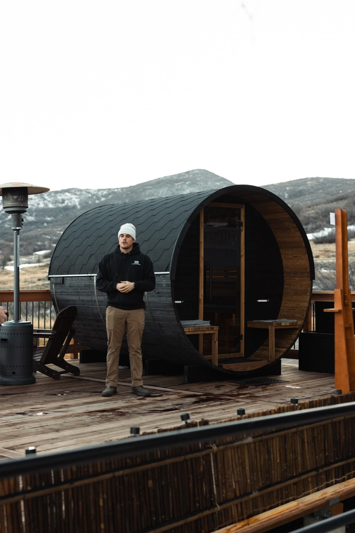 Guest in front of the mountain-view barrel sauna at Soldier Hollow