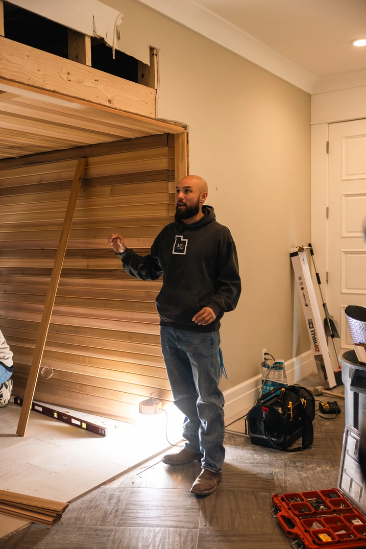 Installer working on cedar wall framing inside the Bountiful home sauna