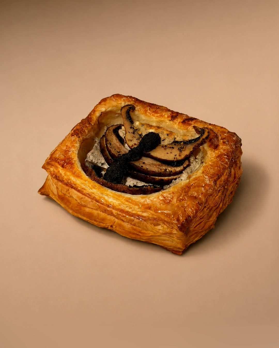 Truffle mushroom and feta, a square laminated pastry with a raised golden border, filled with whipped feta, a fan of roasted mushrooms and slices of black truffle.