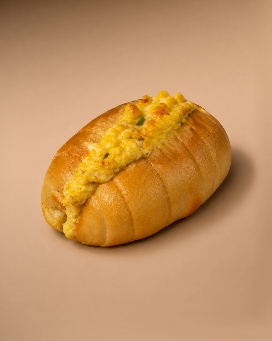 Corn cheese salt bread, split and filled with whole sweetcorn kernels in browned melted cheese, flecked with spring onion and coarse black pepper.