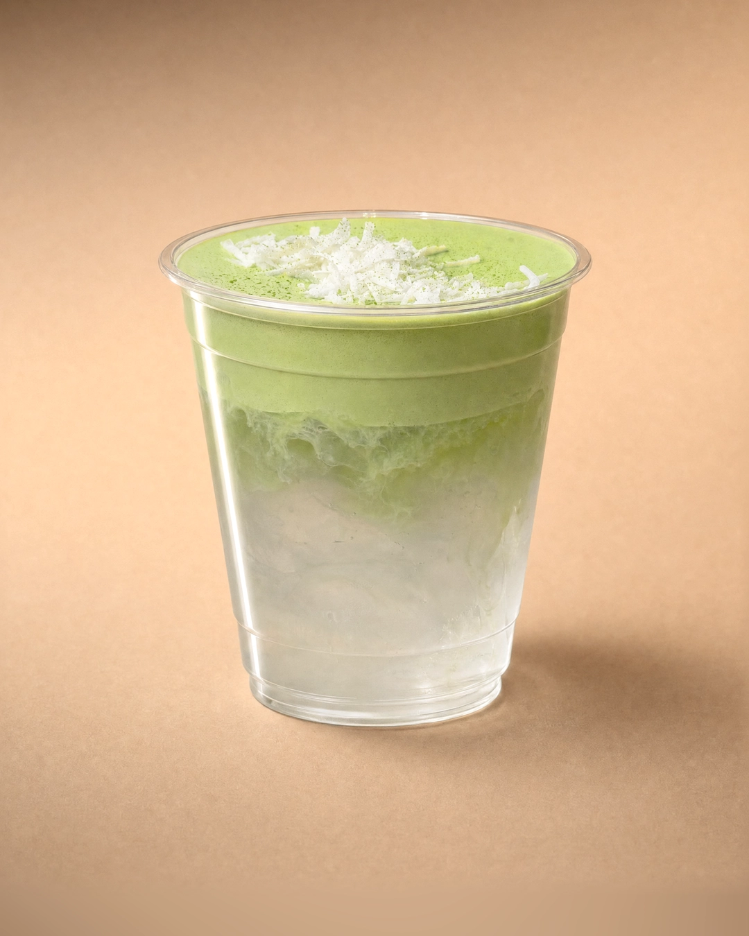 Coconut matcha cloud, clear coconut water and ice below a thick pale green matcha cold foam, finished with shredded coconut and a light dusting of matcha.