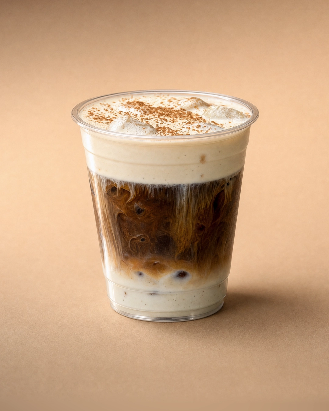 Cà phê muối (salted coffee), dark Vietnamese coffee marbled through pale milk and ice under a thick ivory salted cold foam with soft peaks and a fine brown dusting.