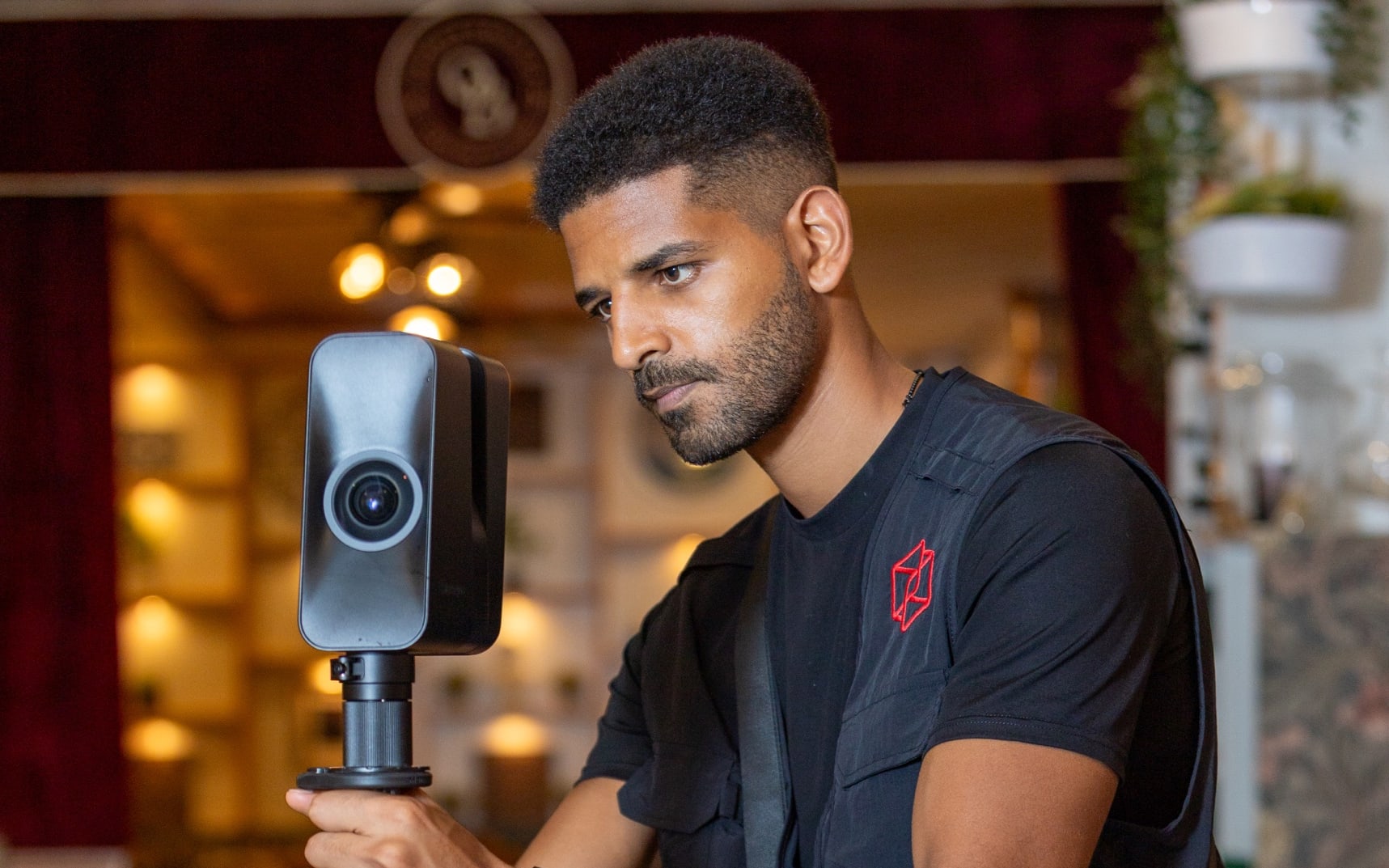 A Spatialist setting up a Matterport Pro3 camera on a tripod inside a restaurant