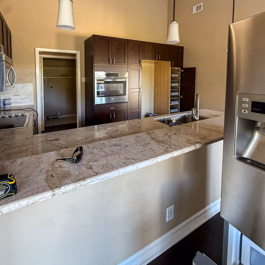 Original Westlake kitchen with dark wood cabinets, granite countertops, and an enclosed layout