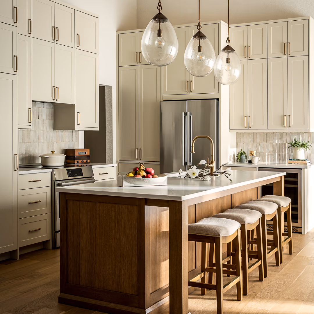 Open kitchen layout featuring an oversized island, pendant lighting, and custom cabinetry