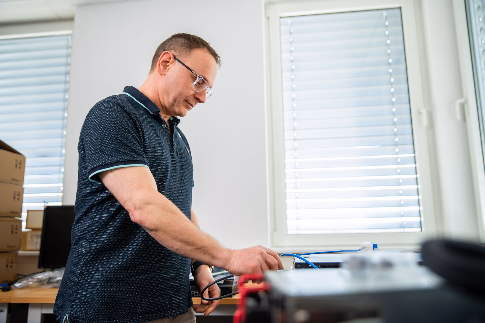 Techniker prüft Netzwerktechnik an der Werkbank