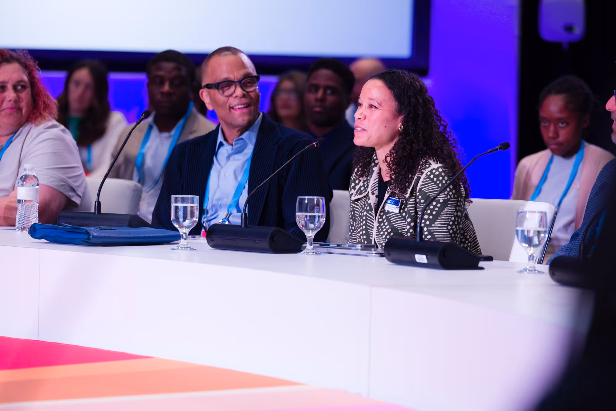 Philip sits on a panel and smiles in discussion with his colleague