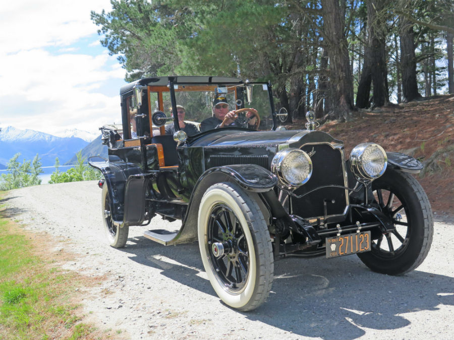 People driving a classic car at Wheels at Wanaka.