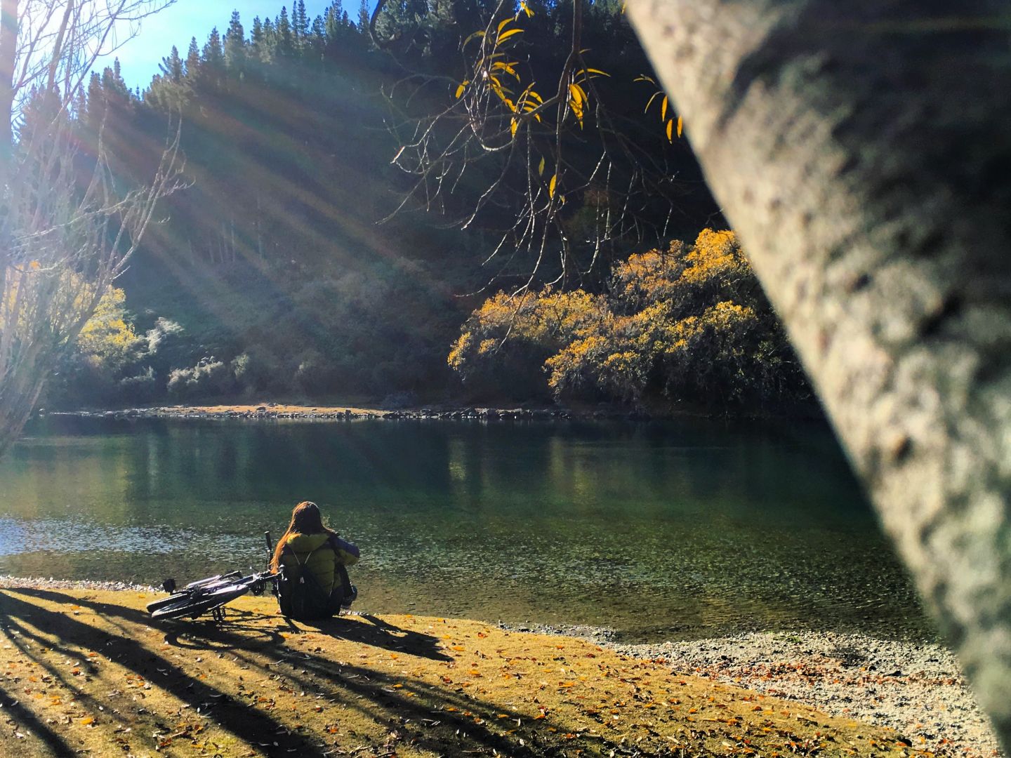 A cyclist relaxes lakefront in Wanaka, during a stay at Wanaka Top 10 Holiday Park.