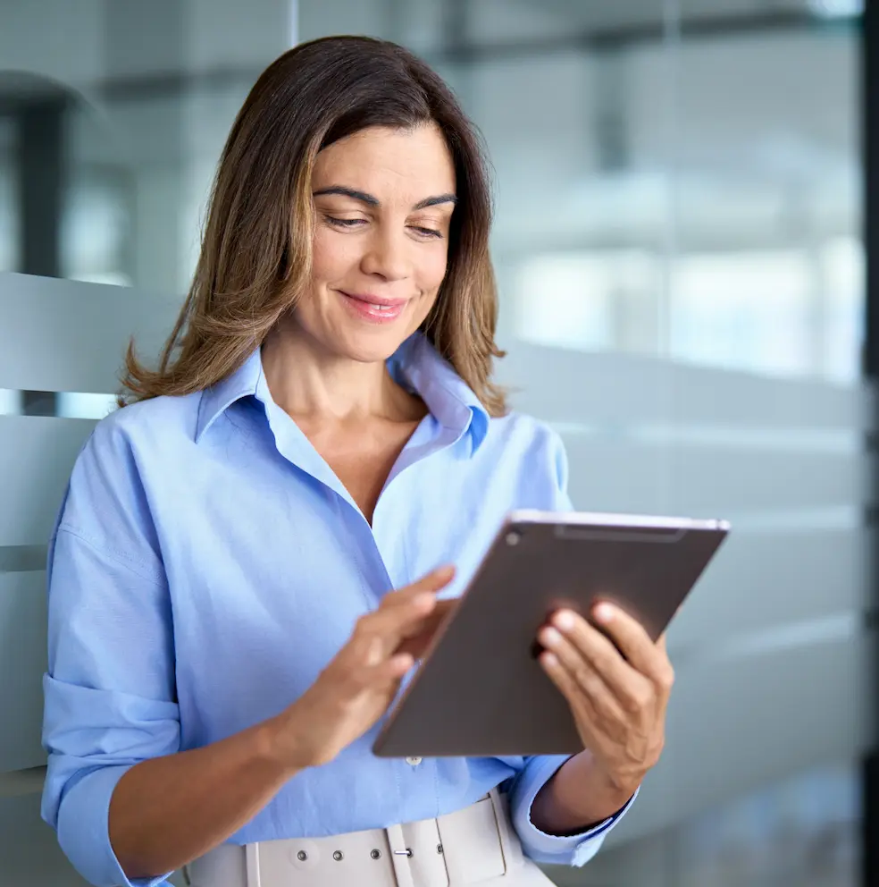 Smiling businesswoman using a tablet in a modern office.