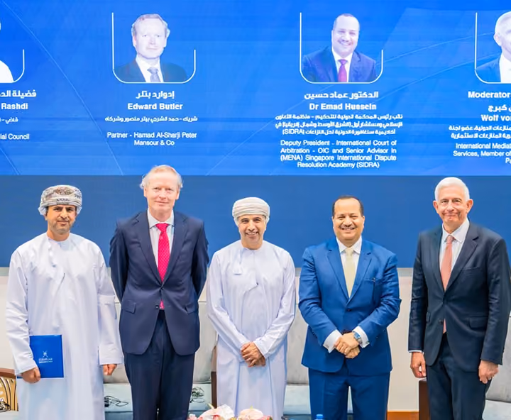 Dr Emad Hussein on stage with fellow speakers at a dispute resolution conference in Oman