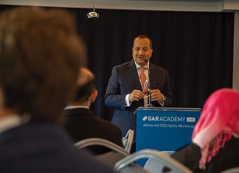 Speaker addressing delegates from the podium at an arbitration conference