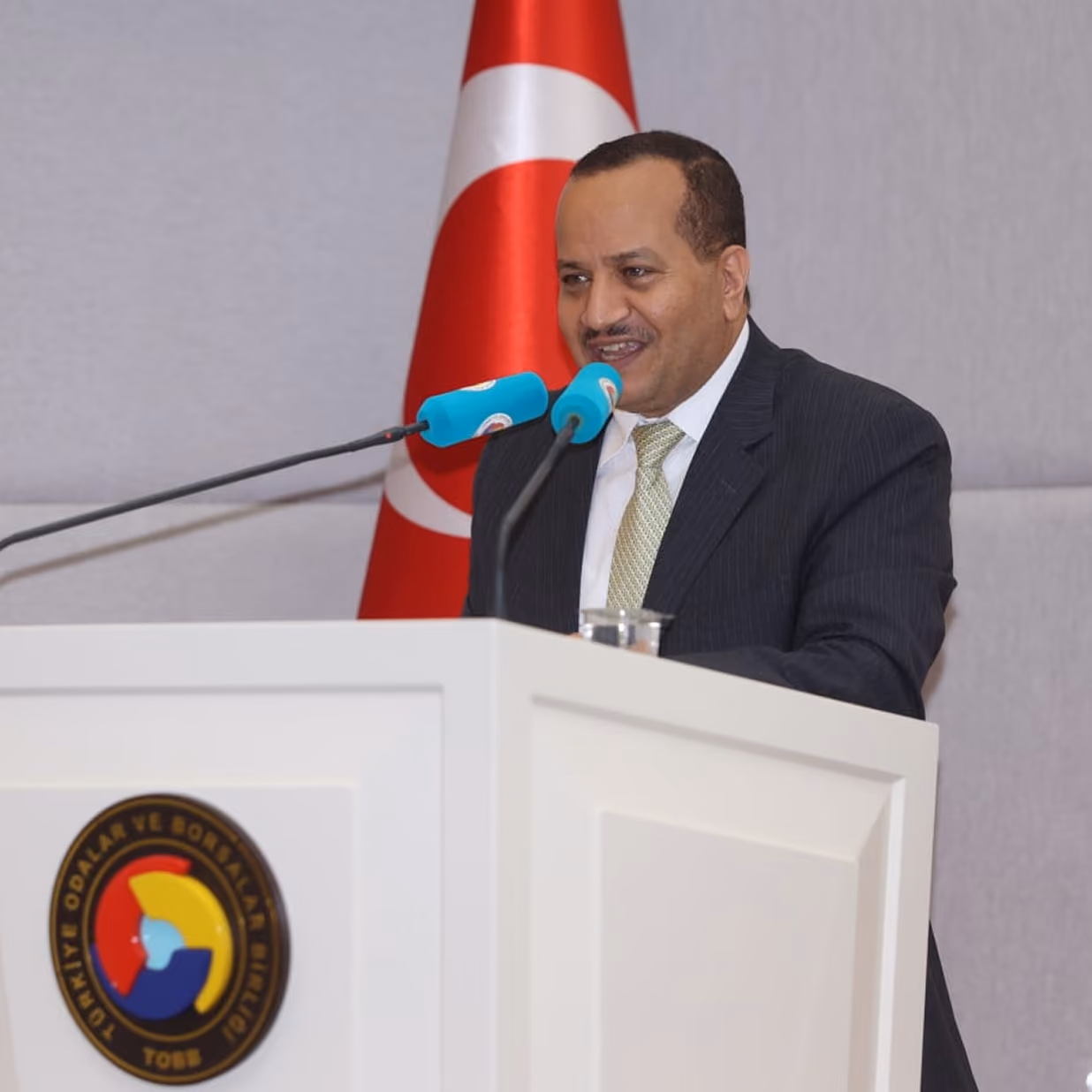 Dr Emad Hussein in a dark grey suit speaking informally at a professional event