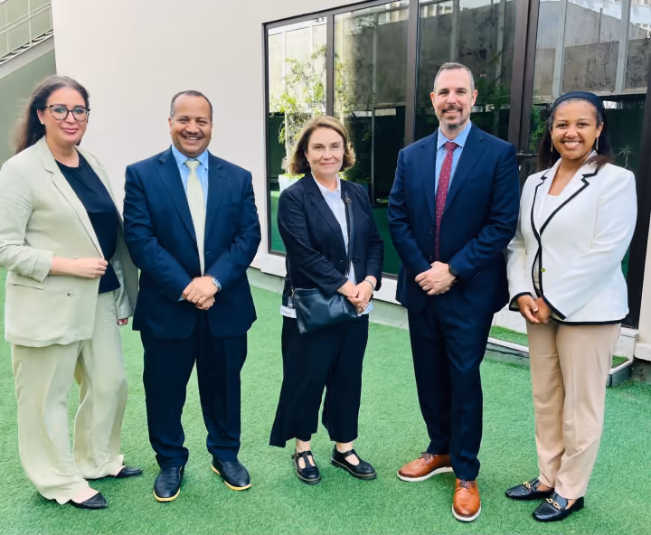Dr. Emad Hussein posing with fellow professionals outside a modern office building.