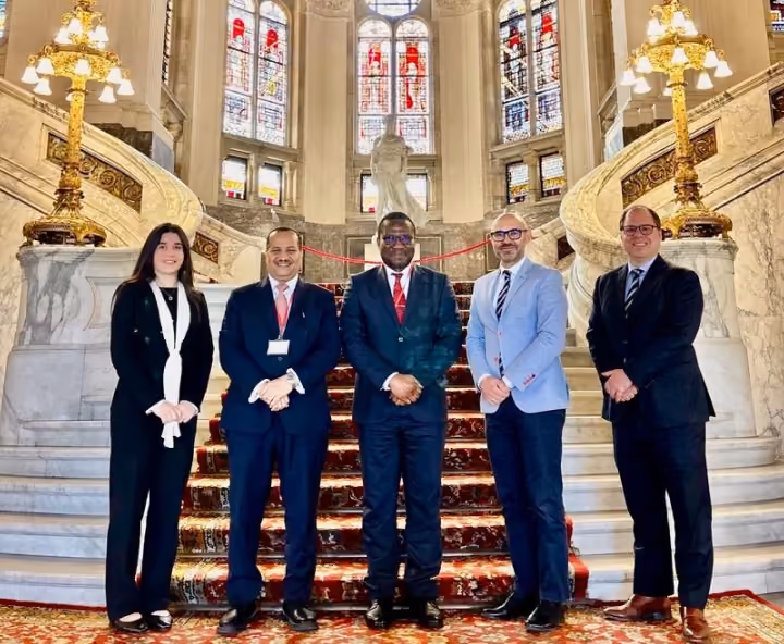 Dr. Emad Hussein standing with fellow professionals on an ornate staircase at an international event.